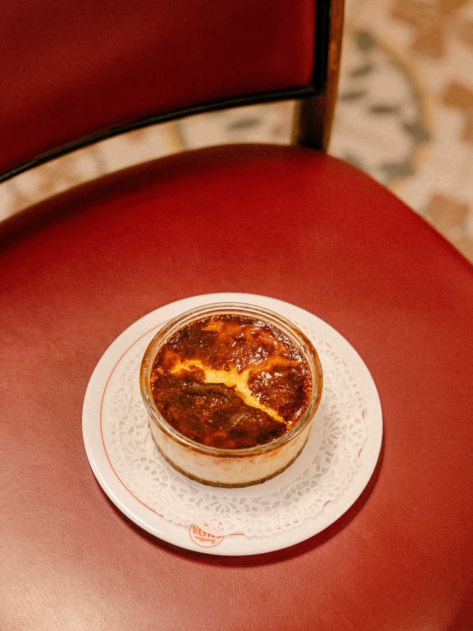 Crème caramel en ramequin, posée sur la banquette rouge du Bouillon Saleya