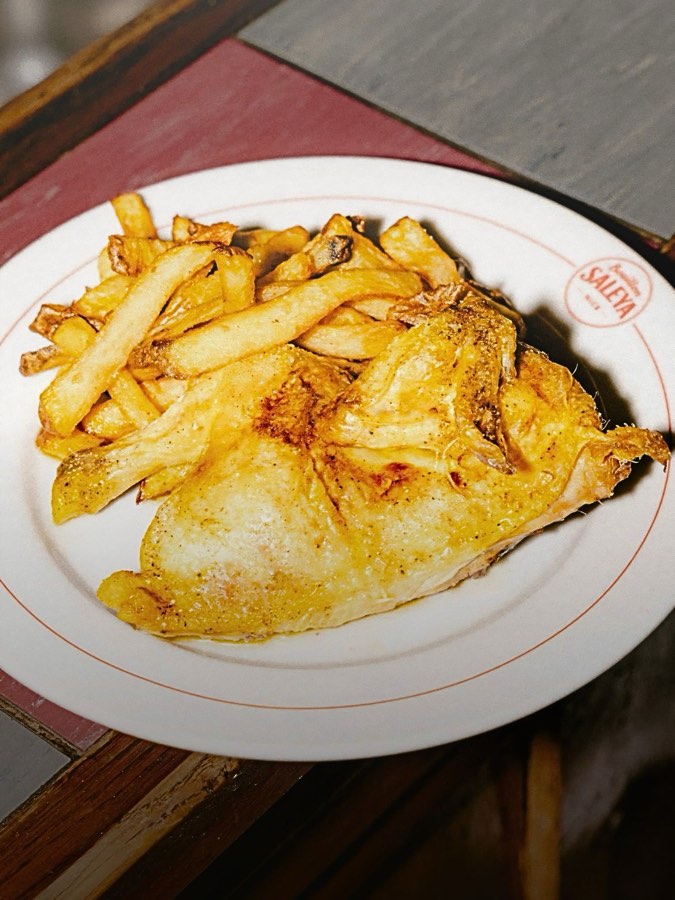 Demi-coquelet rôti et ses frites, sur la nappe au liseré rouge